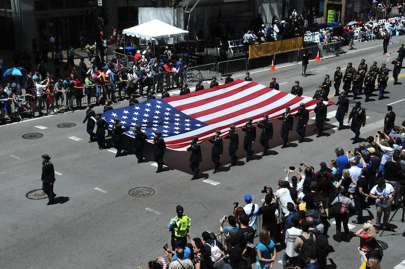 Chicago high school junior ROTC cadets carry a large flag during the City of Chicago Memorial Day parade, Mar. 25, 2019.