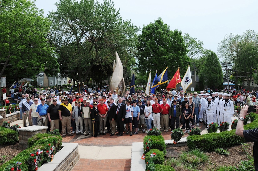 Service members, and veterans pause for a photo following the Village of Arlington Heights Centennial Memorial Day commemoration, Mar. 27, 2019.
