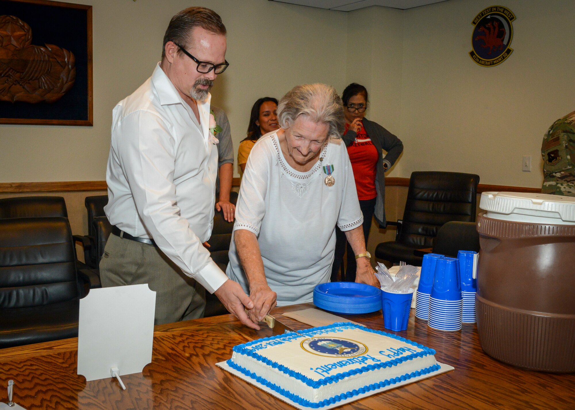 Patricia Henrich cuts a cake celebrating her retirement after 67 years of federal civilian service following her retirement ceremony at Edwards Air Force Base, Calif., May 31. (U.S. Air Force photo by Giancarlo Casem)