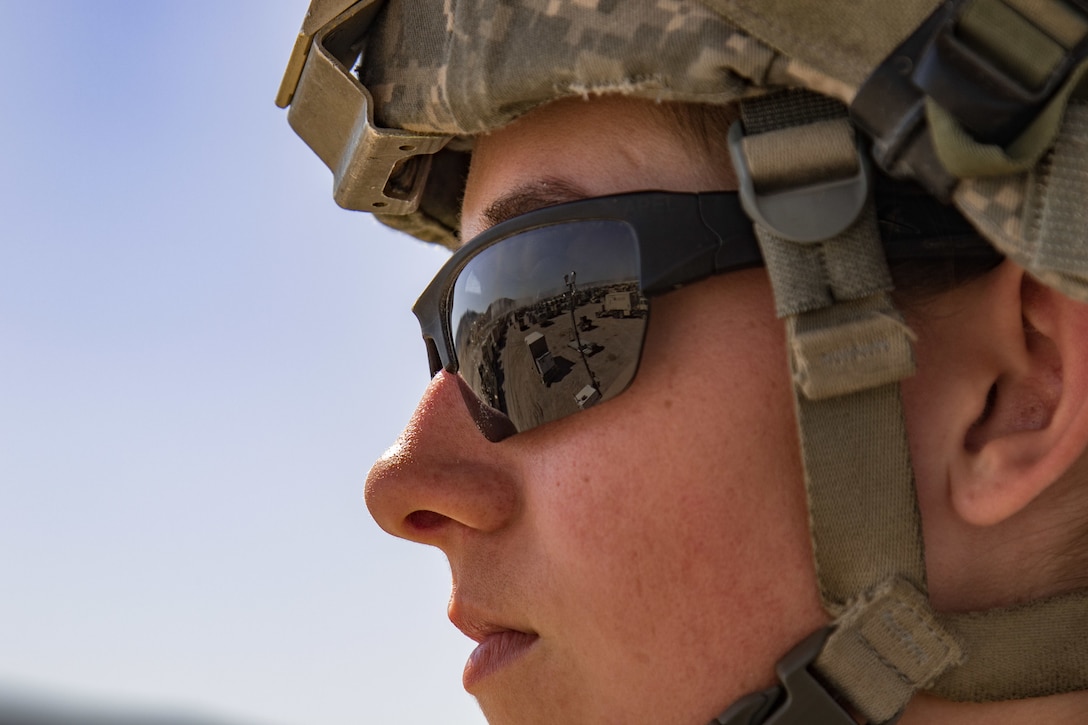 A close shot of a woman wearing a helmet and reflective sunglasses.