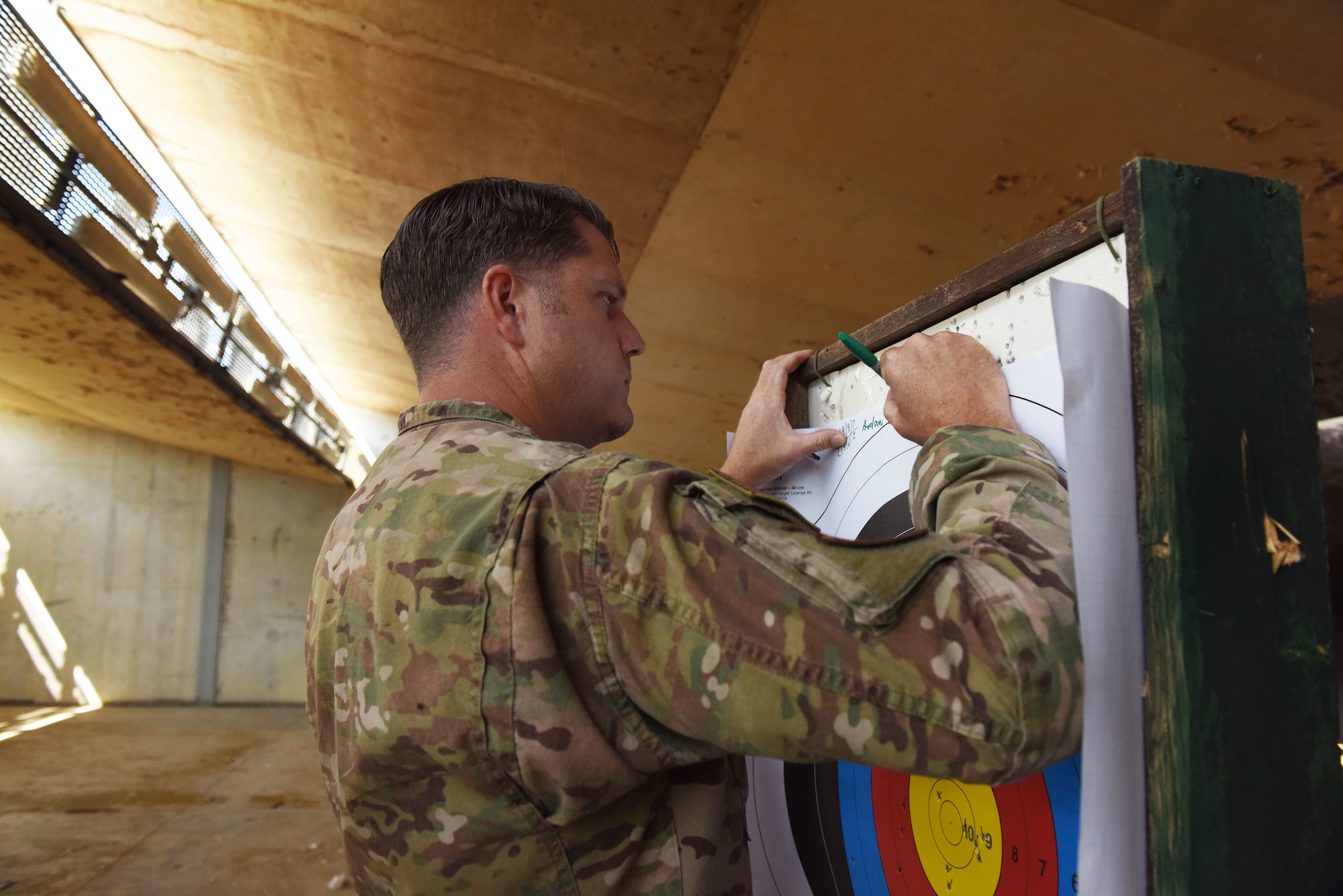U.S. Air Force Tech. Sgt. Andrew Brown, an Excellent in Competition participant, signs his target after the competition hosted by the 39th Security Forces Squadron Oct. 28, 2019, at Incirlik Air Base, Turkey. Participants in the competition earned points based on the number of shots they landed in the two innermost rings of their respective targets. (U.S. Air Force photo by Staff Sgt. Joshua Magbanua)