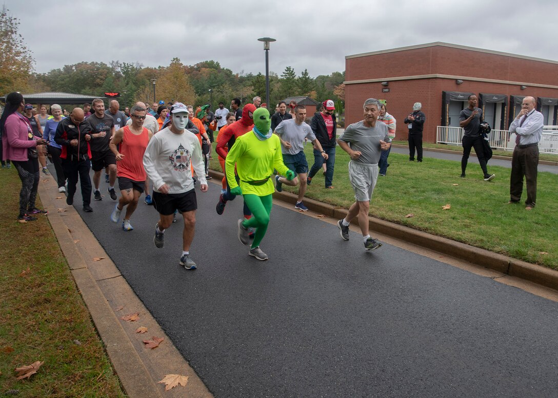 Male and female runners and walkers begin the Halloween-themed 5K.