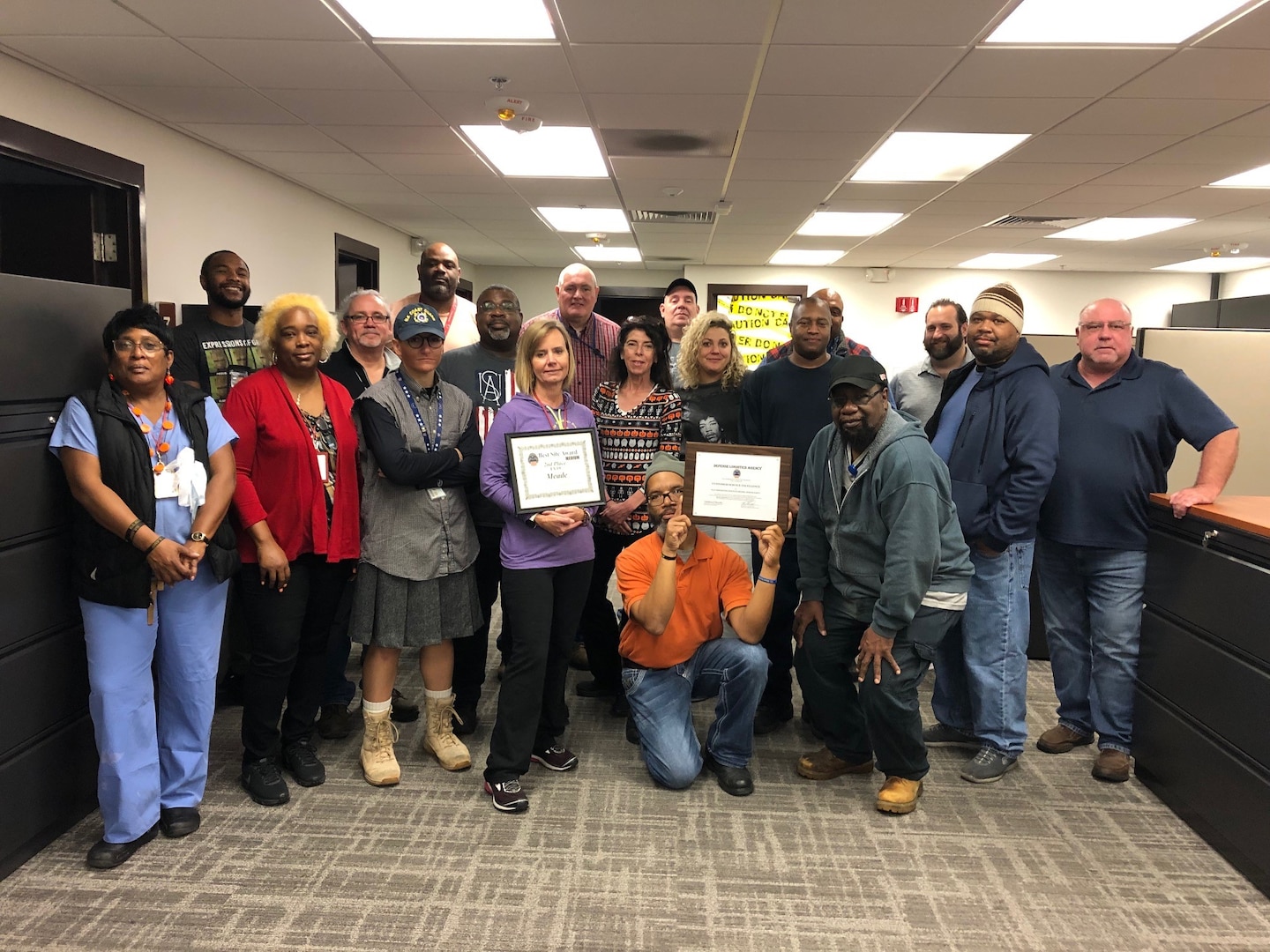 DLA Disposition Services at Fort Meade team pose with two certificate awards