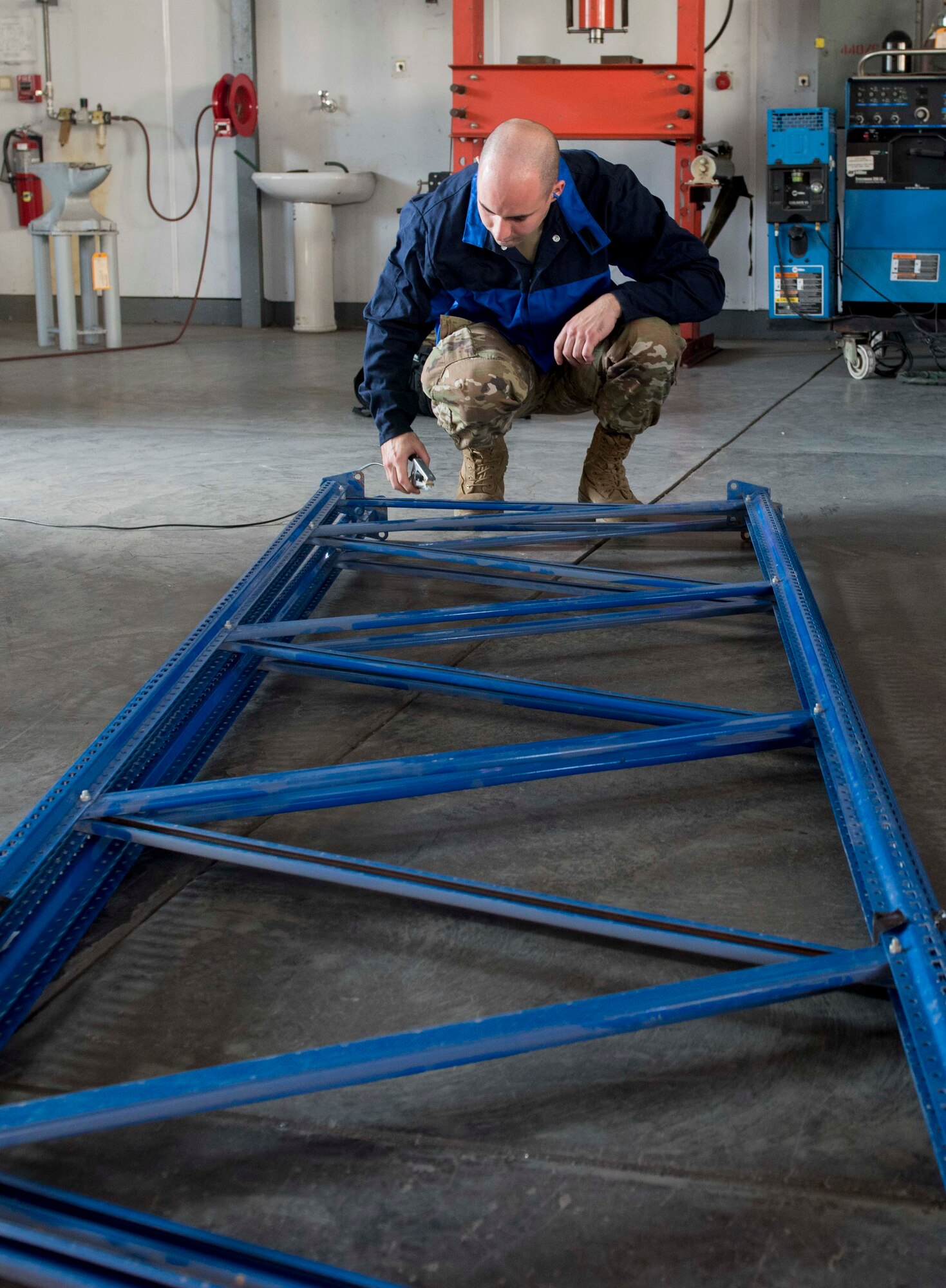 U.S. Air Force Staff Sgt. Jason Barnes, 39th Maintenance Squadron aircraft metals technology technician, removes a grounding clamp from a metal railing, Oct. 25, 2019, at Incirlik Air Base, Turkey.  Grounding an object allows metals technicians to operate plasma cutters safely due to the electric current used by the cutters. (U.S. Air Force photo by Staff Sgt. Trevor Rhynes)