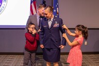 U.S. Air Force Master Sgt. Christina Anders has her rank pinned on by her son, daughter and Aaron Plichta, a member of Joint Task Force Civil Support. Senior Master Sgt. Matthew Larsen, who served with Anders at the 821st Contingency Response Squadron at Travis Air Force Base, Ca., presided over the ceremony and administered the senior non-commissioned officer charges. (Official DoD photo by Mass Communication Specialist 3rd Class Michael Redd/RELEASED)