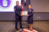 Senior Master Sgt. Matthew Larsen, who served with Master Sgt. Christina Anders at the 821st Contingency Response Squadron at Travis Air Force Base, Ca., presents her with her certificate of promotion during a ceremony at Joint Task Force Civil Support (JTF-CS). Anders was pinned by her son, daughter and Aaron Plichta, a member of JTF-CS. (Official DoD photo by Mass Communication Specialist 3rd Class Michael Redd/RELEASED)