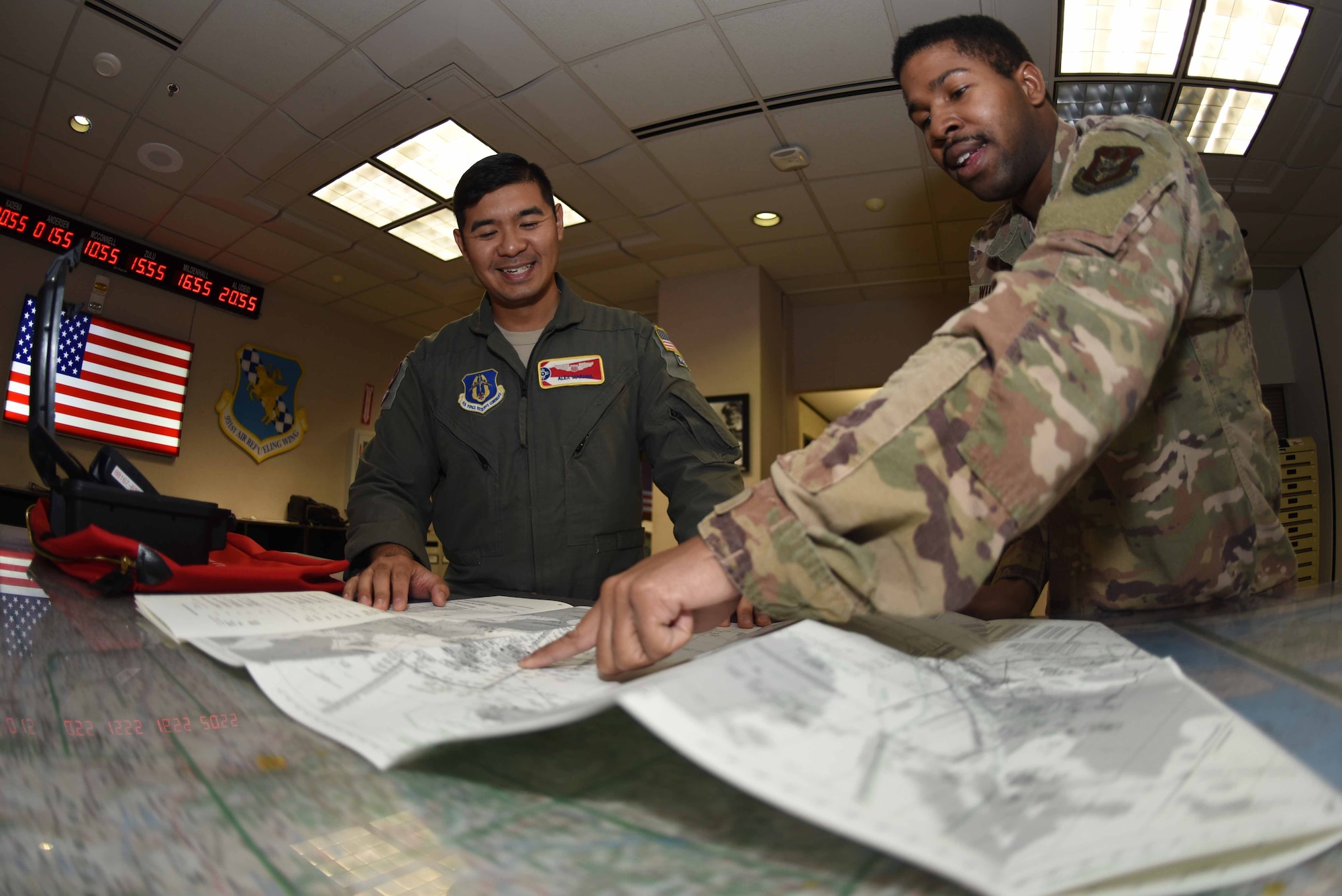 Senior Airman Dwayne Wilson, 22nd Operations Support Squadron combat crew communications technician, discusses flight plans with Maj. Alex Marana, 924th Air Refueling Squadron pilot, Oct. 30, 2019, at McConnell Air Force Base, Kan. When making flight plans, Wilson used a Flight Information Publication to show Marana the terrain data, as well as the authorized airports. (U.S. Air Force photo by Airman 1st Class Alexi Bosarge)