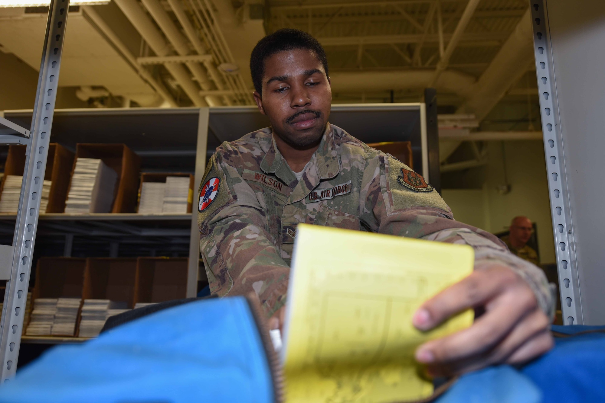 Senior Airman Dwayne Wilson, 22nd Operations Support Squadron combat crew communications technician, looks through a Worldwide Flight Information Publication bag Oct. 30, 2019, at McConnell Air Force Base, Kan. The combat crew communications shops’ main goal is to ensure the security of all aircrew communications during their flights. This includes training aircrew on the use of a variety of materials to help securely talk over the air. (U.S. Air Force photo by Airman 1st Class Alexi Bosarge)