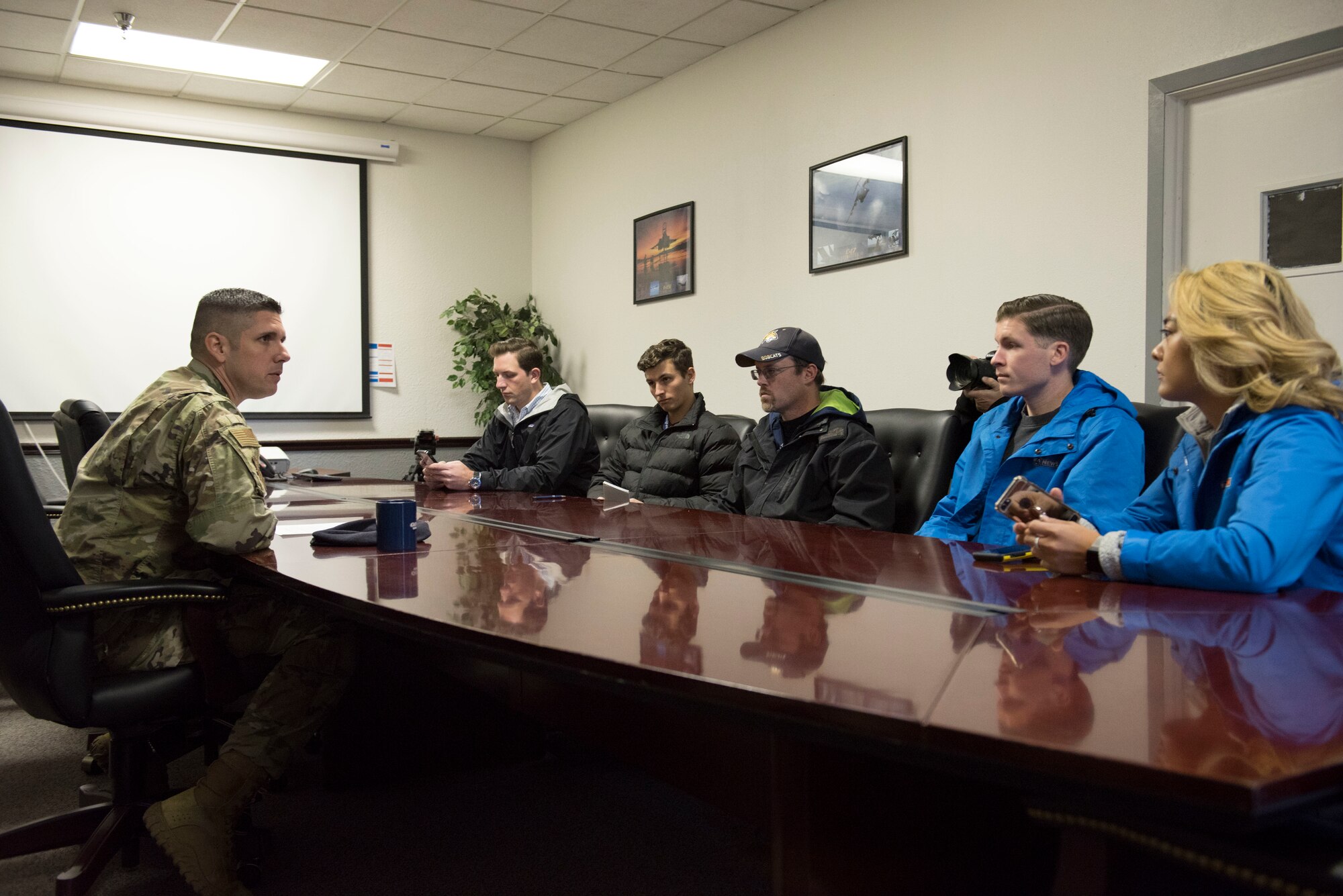 Chief Master Sgt. Thomas Henzl, 92nd Security Forces Squadron security forces manager, greets six members of local Spokane news agencies during a Year of the Defender media day event at Fairchild Air Force Base, Washington, Oct. 29, 2019. YotD is part of a security forces revitalization initiative that aims to update and upgrade combat Airmen units that have been worked hard since the terrorist attacks of 9/11. (U.S. Air Force photo by Senior Airman Ryan Lackey)