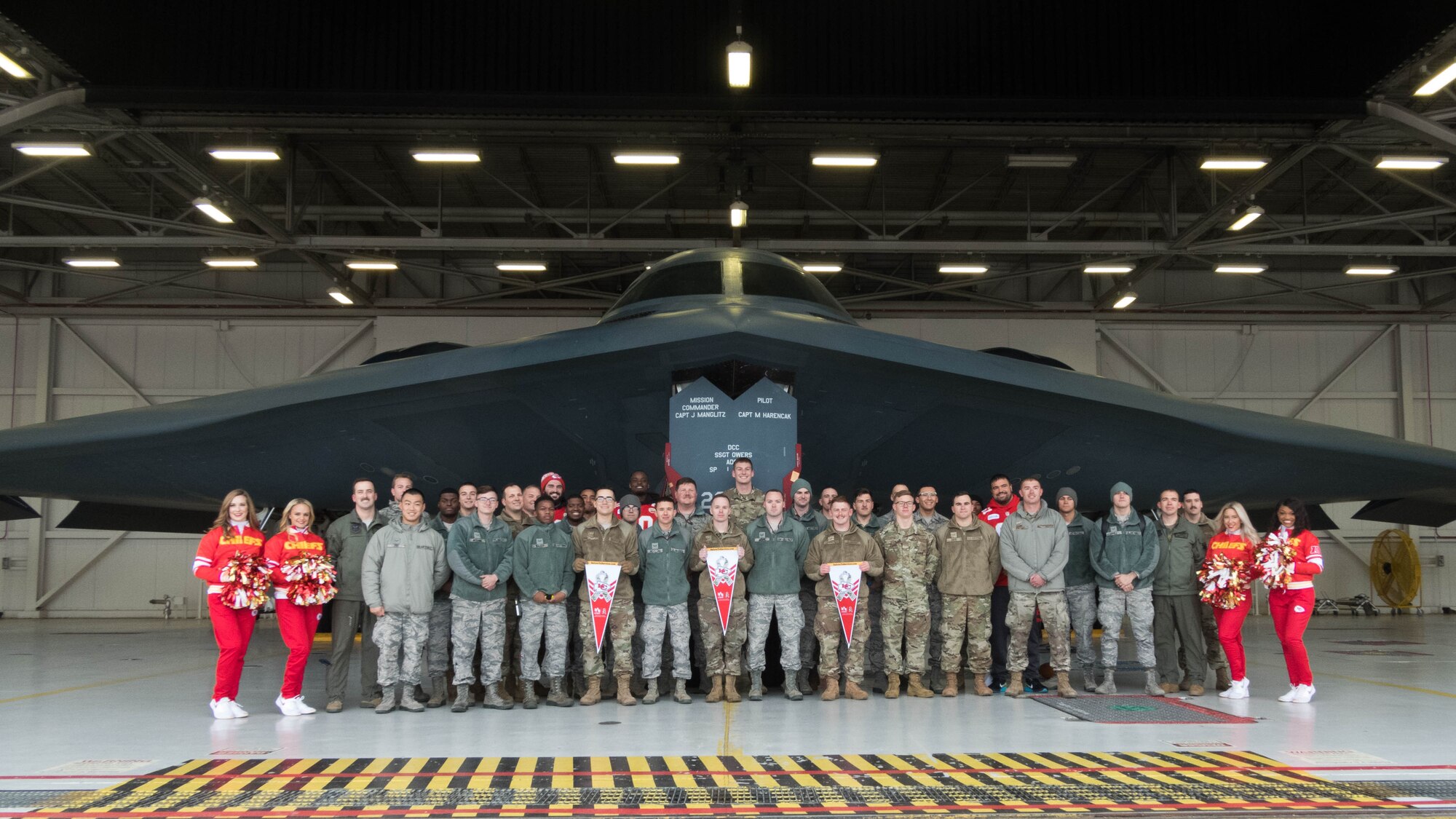 National Football League’s Kansas City Chiefs linemen and cheerleaders pose for a photo in front of a B-2 Spirit with members of Team Whiteman.