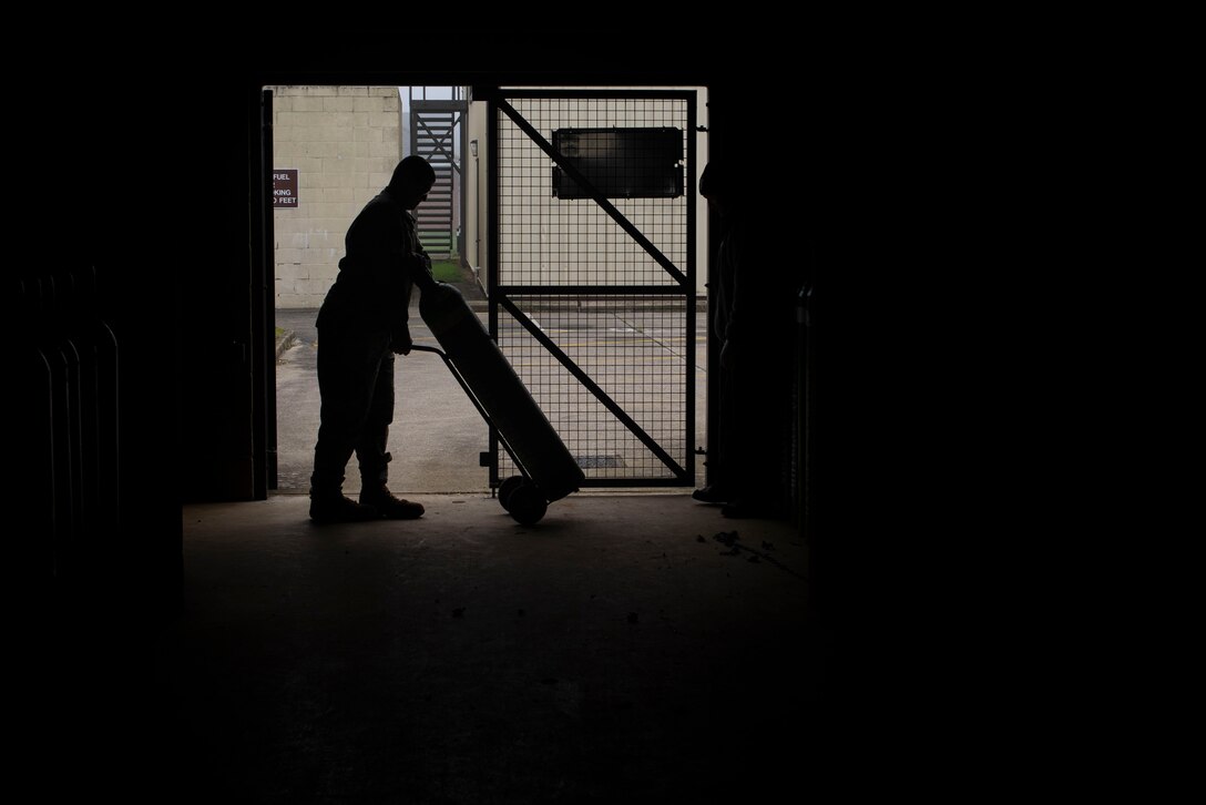 Staff Sergeant Nicholas Tendam, 100th Logistics Readiness Squadron assistant noncommissioned officer in charge of hazmart, moves an oxygen canister Oct. 28, 2019, at RAF Mildenhall, England. The oxygen tanks provide breathing air for pilots and other aircrew of Team Mildenhall. (U.S. Air Force photo by Airman 1st Class Joseph Barron)