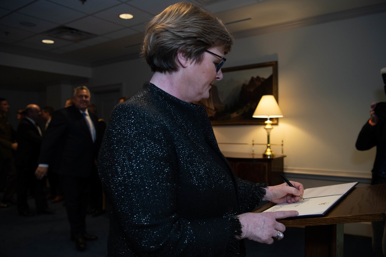 A woman signs a book.