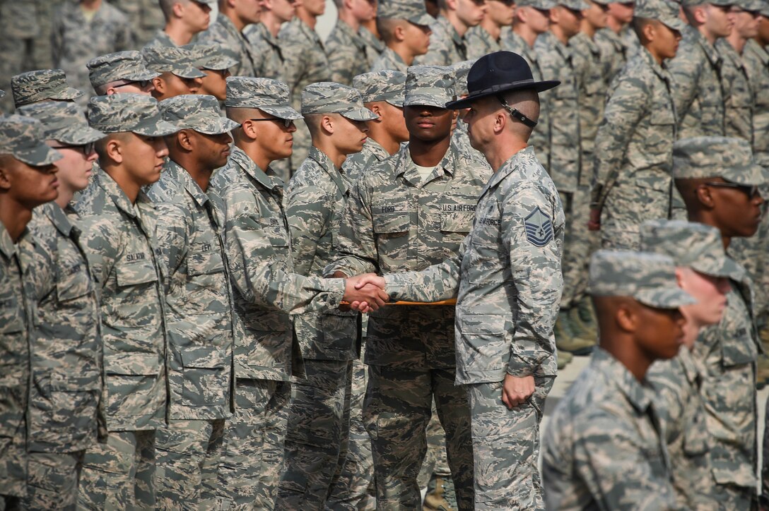 A military training instructor presents an Airman's coin