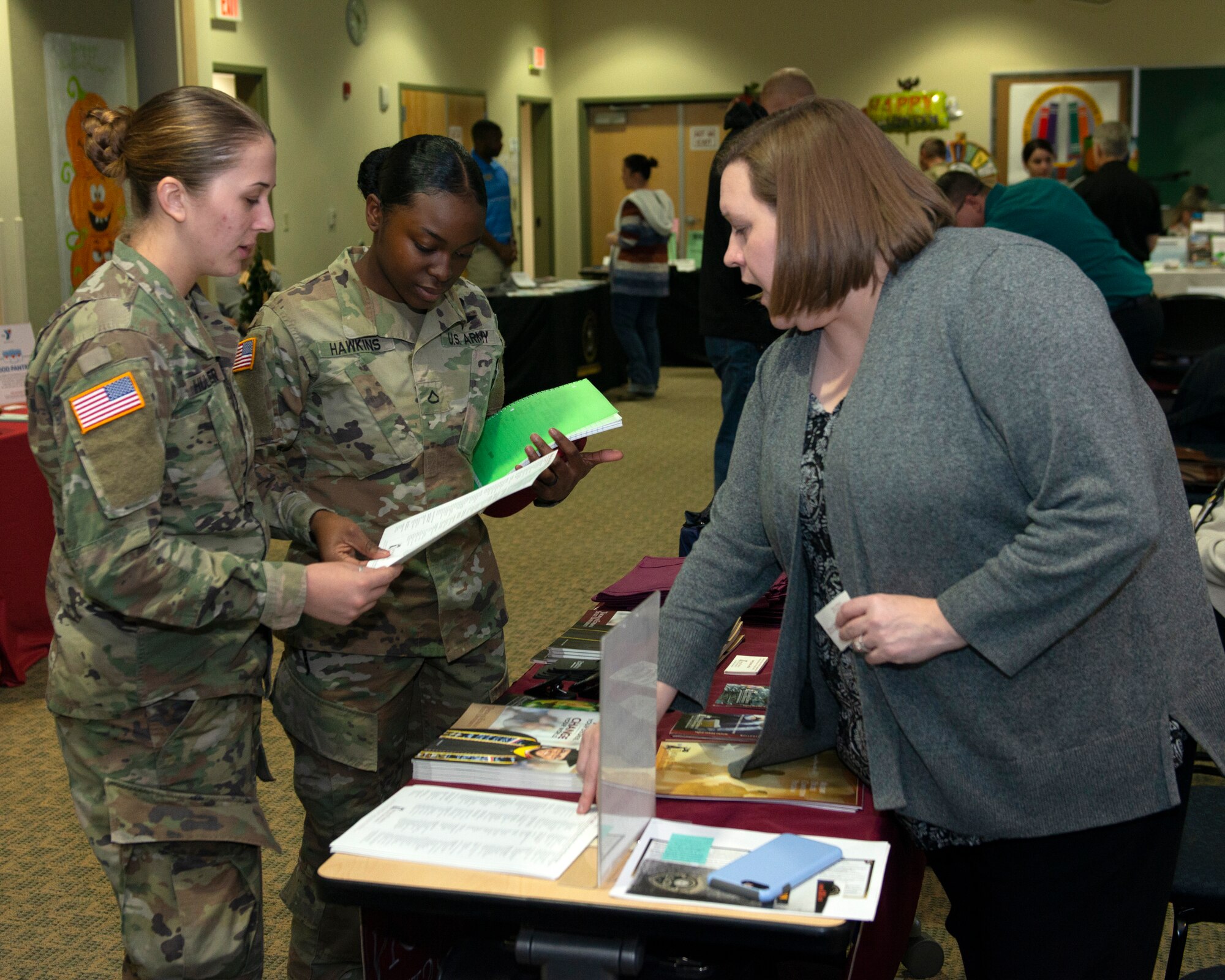 U.S. Army privates first class Whitney Hullander and Armiyah Hawkins, both parachute riggers with the 725th Brigade Support Battalion, 4th Infantry Brigade Combat Team (Airborne), 25th Infantry Division, U.S. Army Alaska, learn about college courses during the Fall Education Fair at Joint Base Elmendorf-Richardson, Alaska, Oct. 31, 2019. The JBER Army Education Center hosted the event, which allowed more than 20 vendors to showcase a variety of educational opportunities.