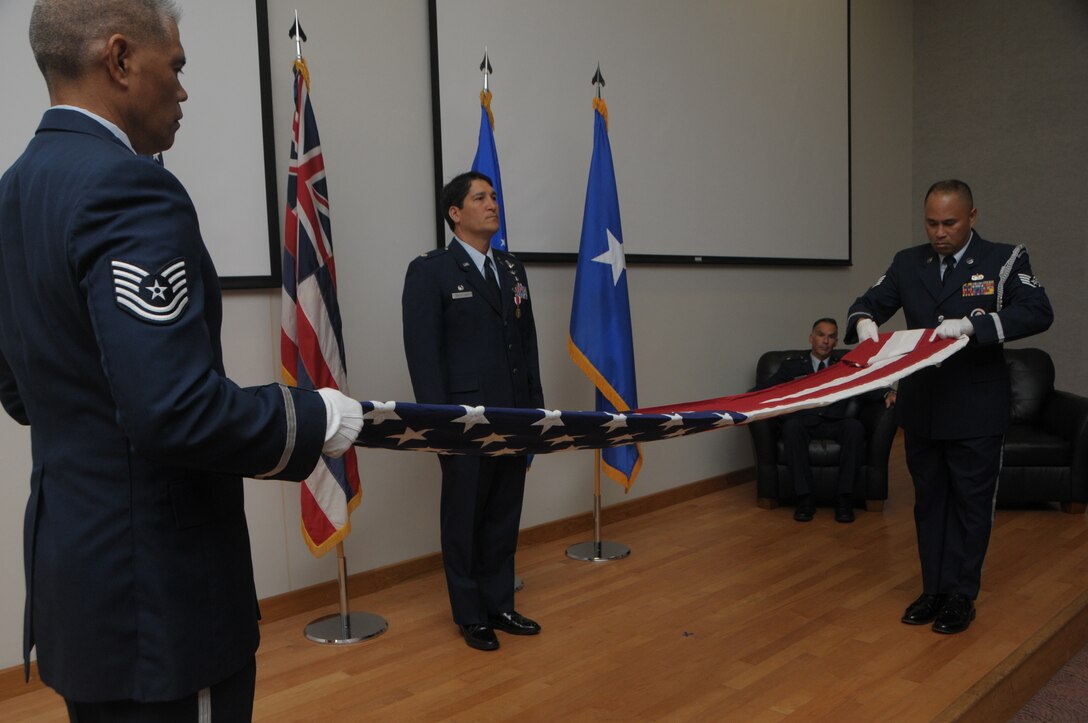 Tech. Sgt. Mark Crabbe and Staff Sgt. Darrell Bactad, 204th Airlift Squadron information managers, fold the U.S. flag during a retirement ceremony Oct. 3, 2015, at Joint Base Pearl Harbor-Hickam, Hawaii. The two friends have performed military ceremonies side-by-side in the Hawaii Air National Guard Honor Guard team since the early 2000s. Crabbe became an honor guardsmen in 2001 and Bactad joined in 1999, when the unit was established. (Courtesy photo)