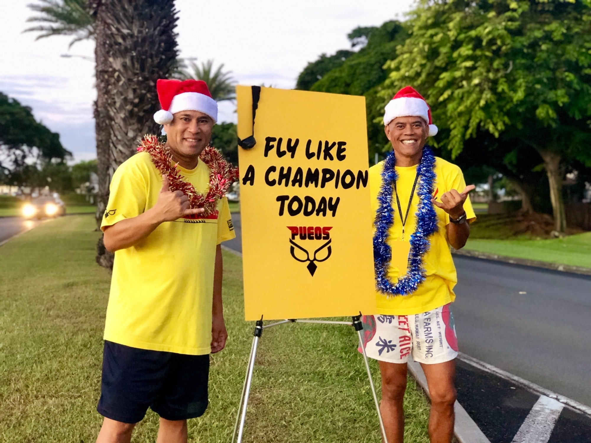 Staff Sgt. Darrell Bactad and Tech. Sgt. Mark Crabbe, 204th Airlift Squadron information managers, welcome inbound traffic as Airmen begin weekend drill Dec. 1, 2018, at Joint Base Pearl Harbor-Hickam, Hawaii. The two friends are advocates of random-acts-of kindness and also longstanding members of the Hawaii Air National Guard Honor Guard team, with nearly 40-years-of-service between the two. (U.S. Air National Guard photo by Senior Airman John Linzmeier)
