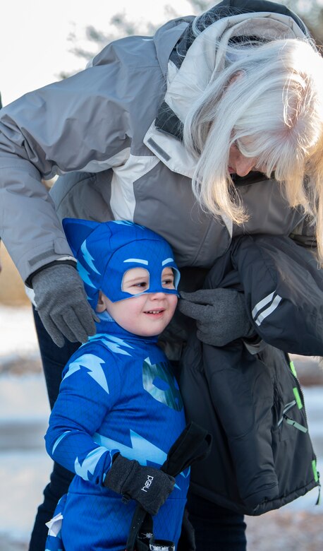 Levi, 2, has his mask adjusted by Leanne Alfrey, his grandmother, during the annual trick-or-treat and Halloween Parade at Schriever Air Force Base, Colorado, Oct. 31, 2019. Children and their families were invited to trick-or-treat and enjoy a parade through on-base housing neighborhoods. (U.S. Air Force photo by Airman 1st Class Jonathan Whitely)