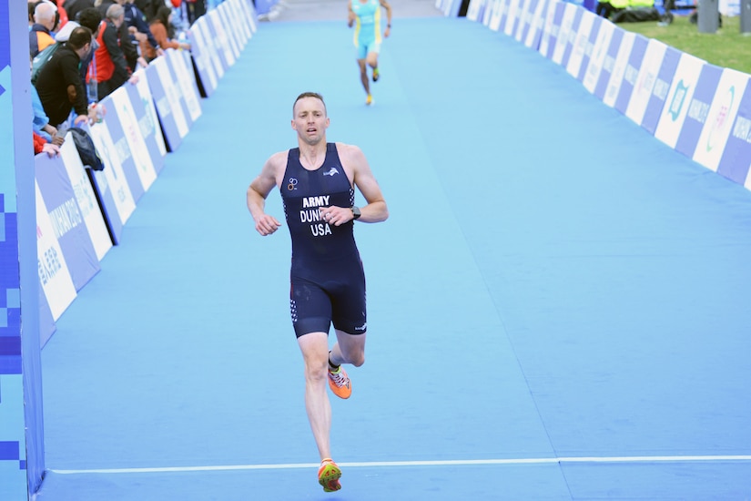 Male triathlete crosses the finish line for the running portion of the event.