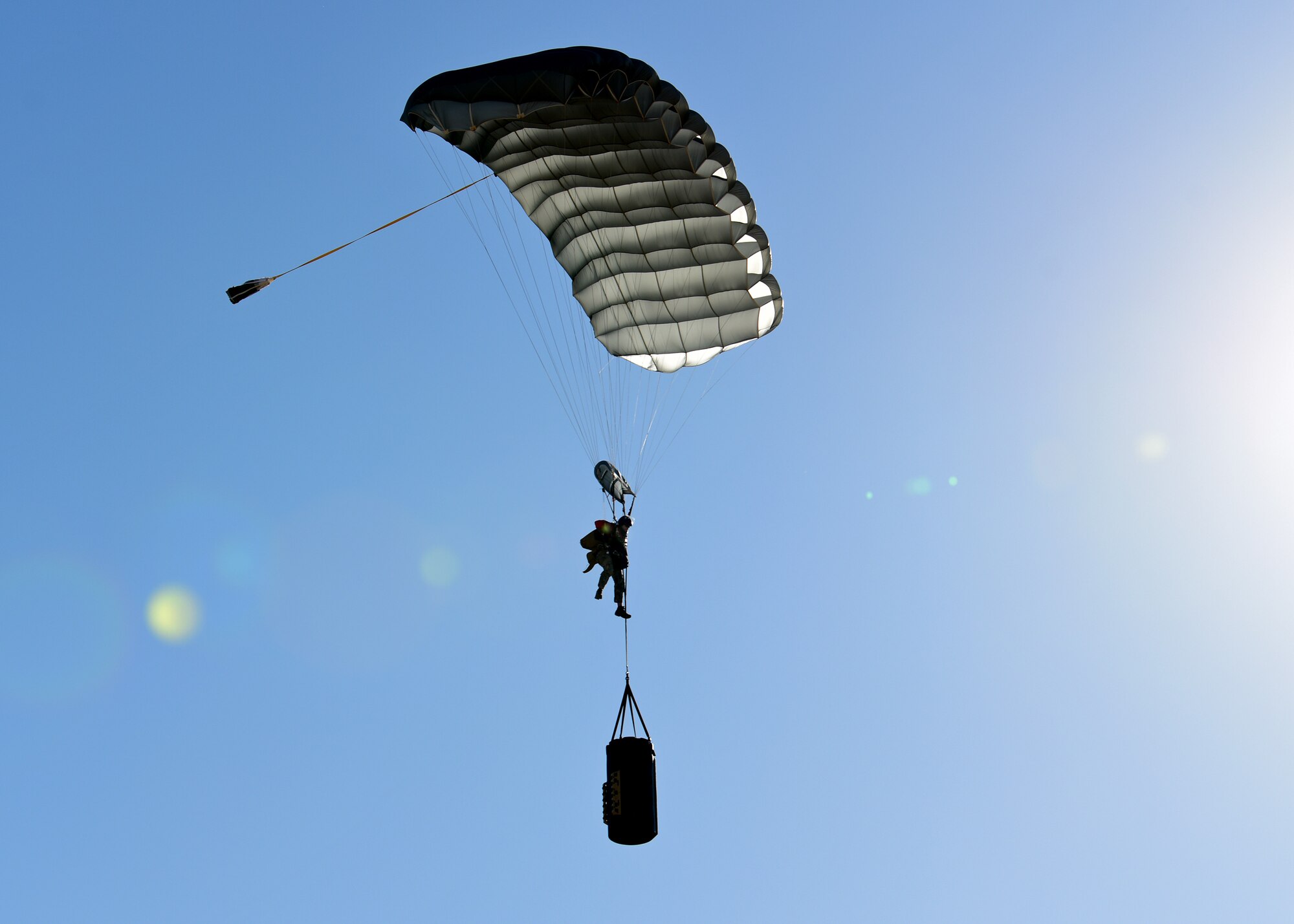 a photo of an airman parachuting with a barrel of socks