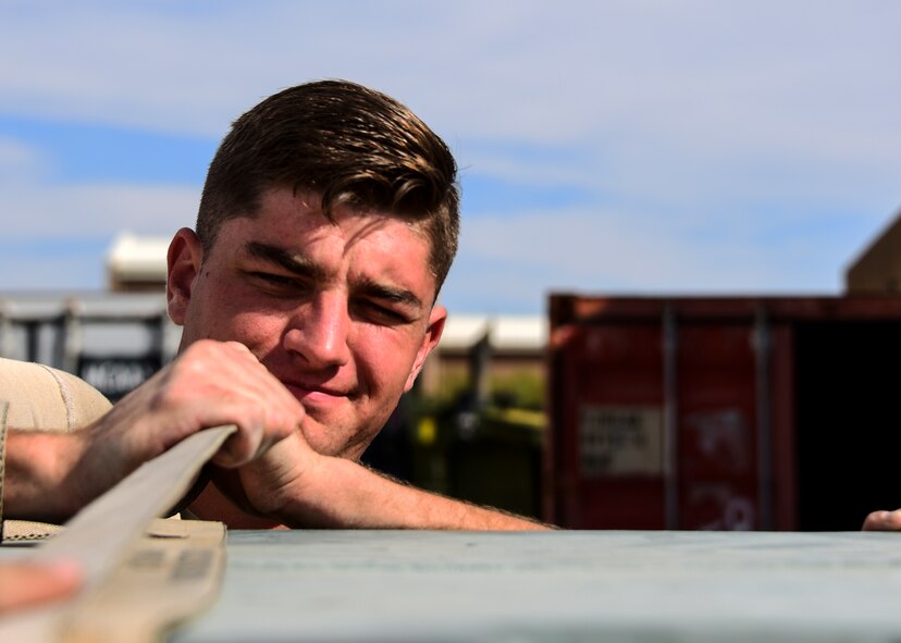 U.S. Air Force Senior Airman Russell King, 355th Civil Engineer Squadron electrician, straps down cargo as he works with the 355th Logistics Readiness Squadron while exercising the Dynamic Wing concept during Bushwhacker 19-08 at Davis-Monthan Air Force Base, Arizona, Oct. 30, 2019. Airmen at Davis-Monthan are learning their role in the joint fight and approaching every scenario with a multi-functional mindset that is focused on mission success. (U.S. Air Force photo by Airman 1st Class Jacob T. Stephens)