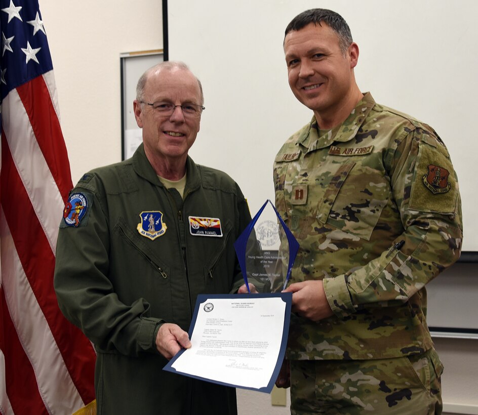 Col. John Rummel, 161st MDG commander presents Capt. James Taylor, 161st MDG medical readiness officer, the ANG Young Health Care Administrator of the year award at Goldwater Air National Guard Base, Phoenix, Nov. 2, 2019. (U.S. Air National Guard photo by Tech. Sgt. Michael Matkin)