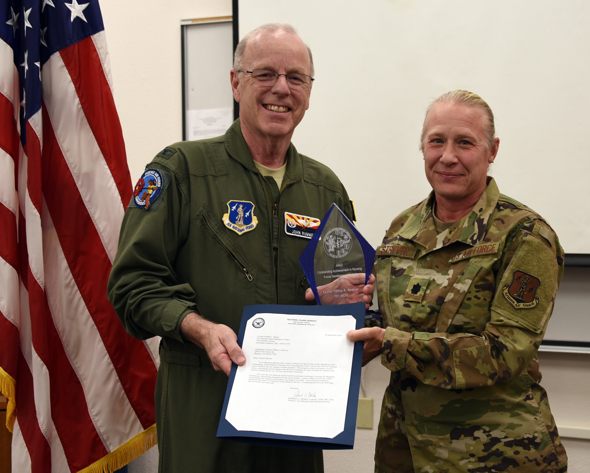 Col. John Rummel, 161st MDG commander presents Lt. Col. Tiffiny Strever, 161st MDG Chief Nurse, the ANG outstanding Achievement in Nursing Development of the Year award at Goldwater Air National Guard Base, Phoenix, Nov. 2, 2019. (U.S. Air National Guard photo by Tech. Sgt. Michael Matkin)