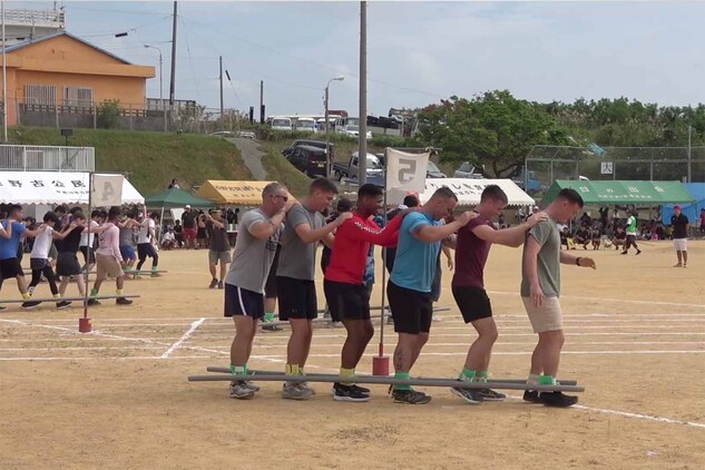 ムカデ競走で息を合わせて前進するキャンプ・シュワブの海兵隊員。沖縄県名護市辺野古区で11月3日（日）、第46回辺野古区民運動会が区民運動場で開催され、米海兵隊基地キャンプ・シュワブと沖縄防衛局も招待され、参加しました。