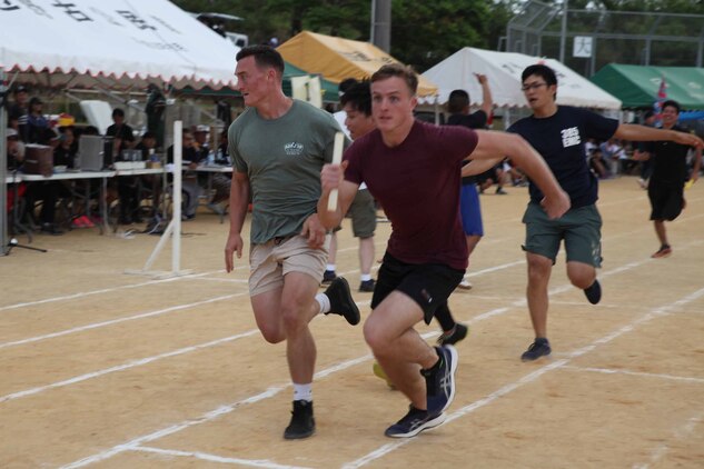 4X200メートルリレーで力走する海兵隊員。沖縄県名護市辺野古区で11月3日（日）、第46回辺野古区民運動会が区民運動場で開催され、米海兵隊基地キャンプ・シュワブと沖縄防衛局も招待され、参加しました。