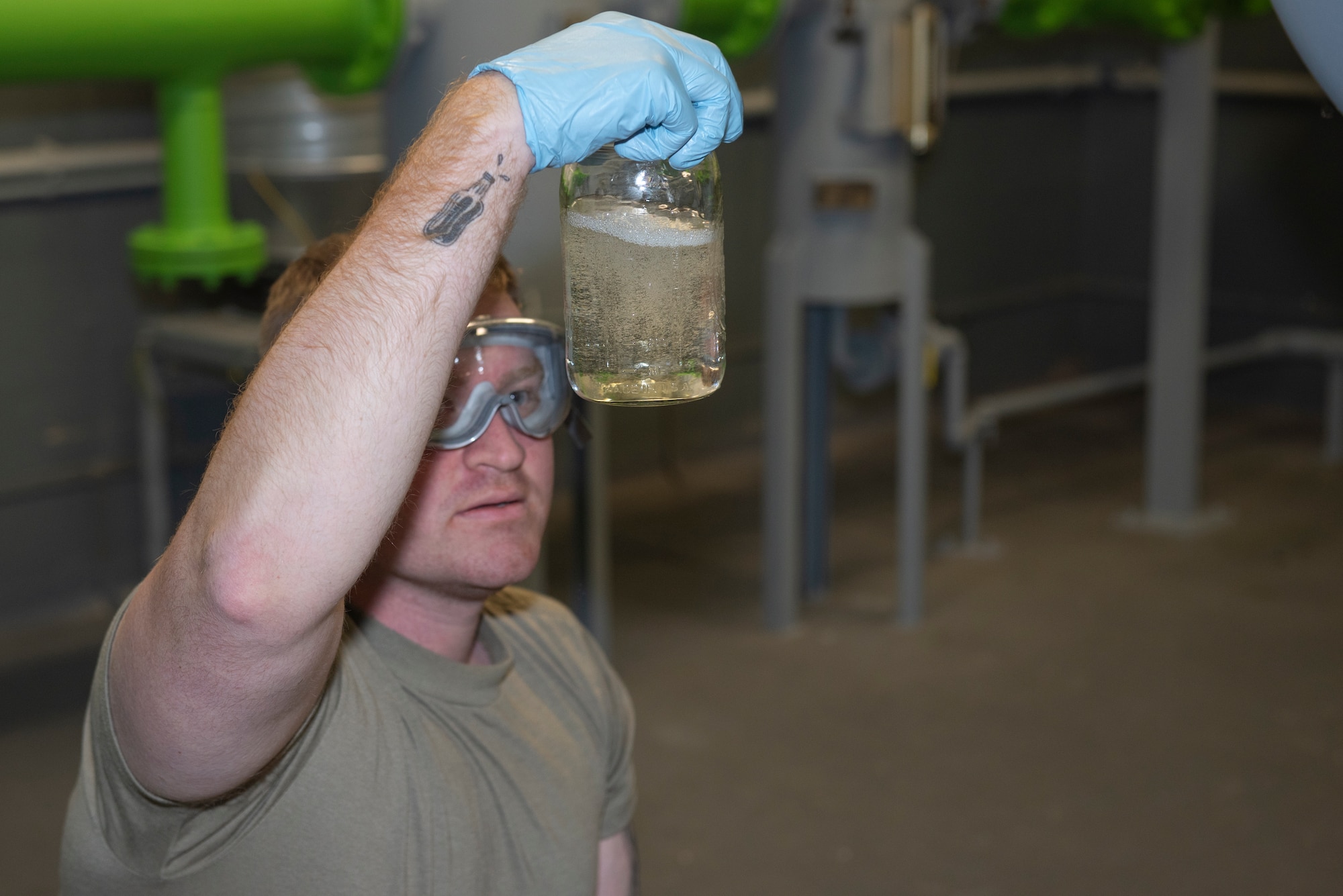 U.S. Air Force Senior Airman Clayton Johnson, 52nd Logistics Readiness Squadron petroleum, oil, and lubricants journeyman, inspects a fuel sample for clarity and debris at Spangdahlem Air Base, Germany, Oct. 29, 2019. Johnson collected samples from two fuel tanks that were brought in from Bellheim, Germany. (U.S. Air Force photo by Airman 1st Class Alison Stewart)