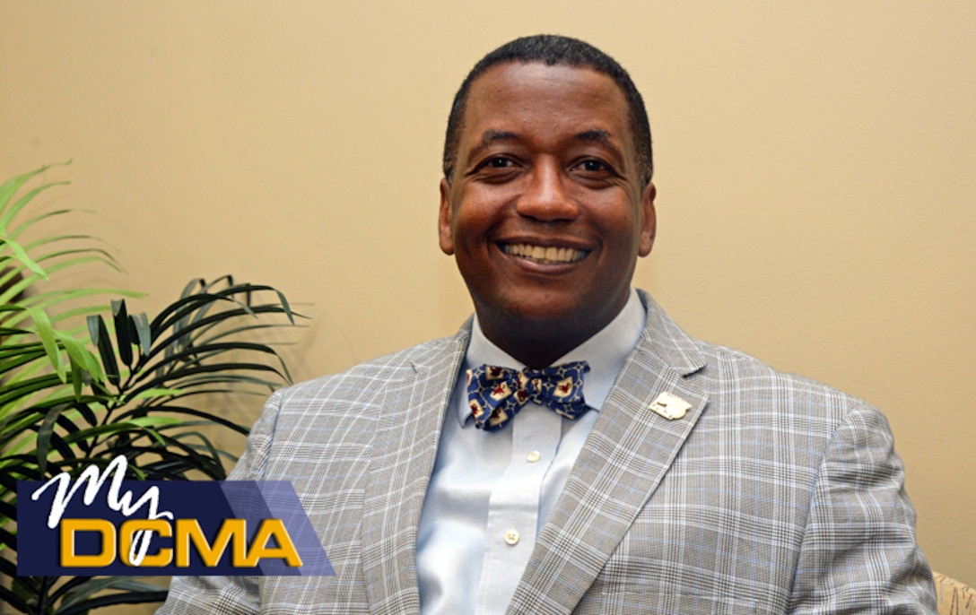 Smiling man wearing a suit sits in a chair