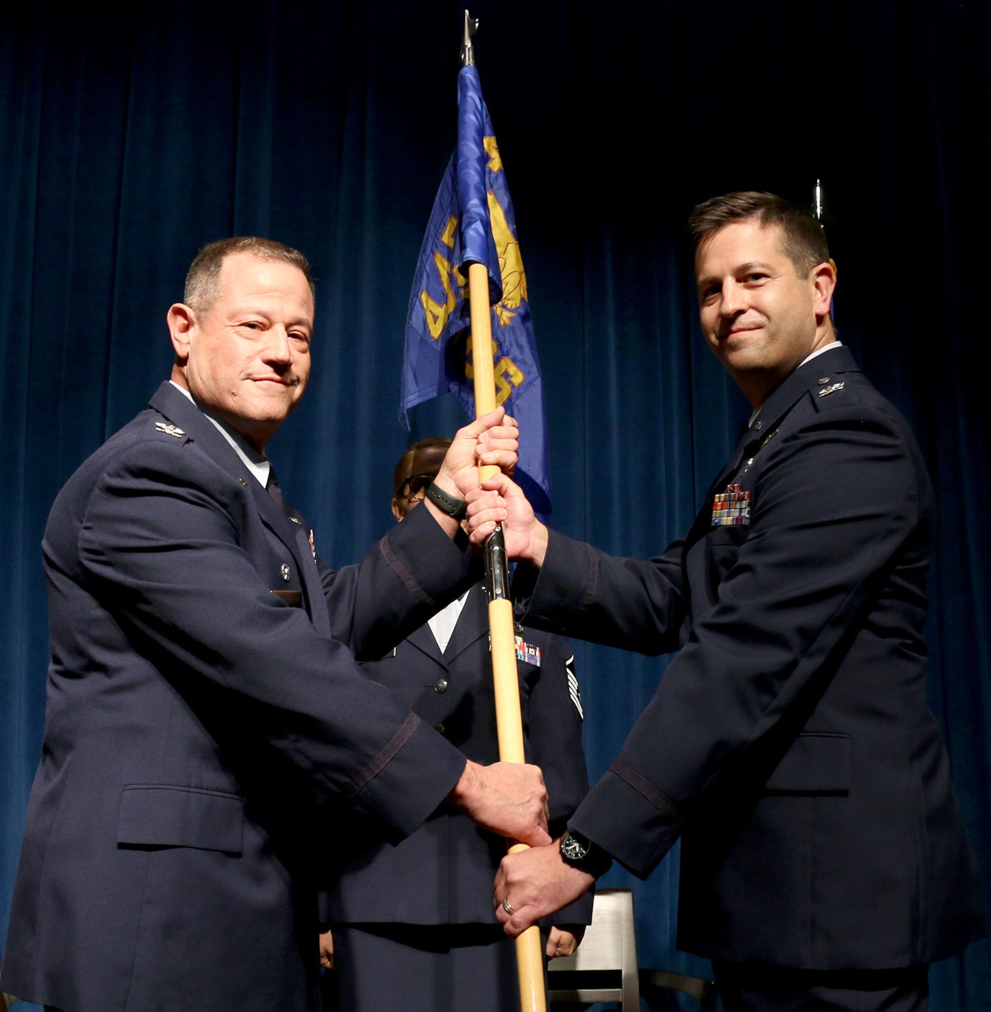 (left) 445th Airlift Wing Commander Col. Adam Willis, passes the guidon to Col. Hans Otto, incoming 445th Aerospace Medicine Squadron commander, during an assumption of command ceremony Oct. 6, 2019 held at the 88th Air Base Wing Medical Group.