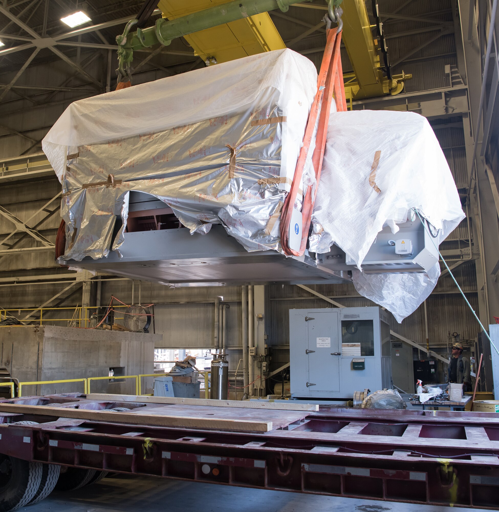 : A worker watches as a 38,000-horsepower motor is lifted by a crane into place at the Arnold Engineering Development Complex Engine Test Facility A Plant at Arnold Air Force Base, Tenn., Oct. 14. The motor will replace two motors that had been in service since 1958. (U.S. Air Force photo by Jill Pickett) (This image was cropped to emphasize the subject.)