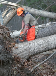 Staff Sgt. Dave Paronett assigned to the 174th Attack Wing, Syracuse, New York, operates a chainsaw to clear fallen trees in Herkimer County after rain and winds on Halloween.