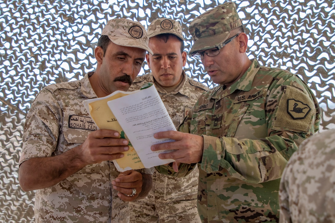 A U.S. Army Soldier, with Military Engagement Team-Jordan, 158th Maneuver Enhancement Brigade, Arizona Army National Guard, discusses a mathematical equation with Jordan Armed Forces-Arab Army (JAF) Soldiers during a Sniper Subject Matter Expert Exchange at a base outside of Amman, Jordan in October 2019. The United States is committed to the security of Jordan and to partnering closely with the JAF to meet common security challenges. (U.S. Army photo by Sgt. 1st Class Shaiyla B. Hakeem)
