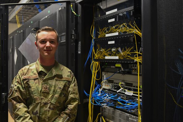 A man stands in front of wires.