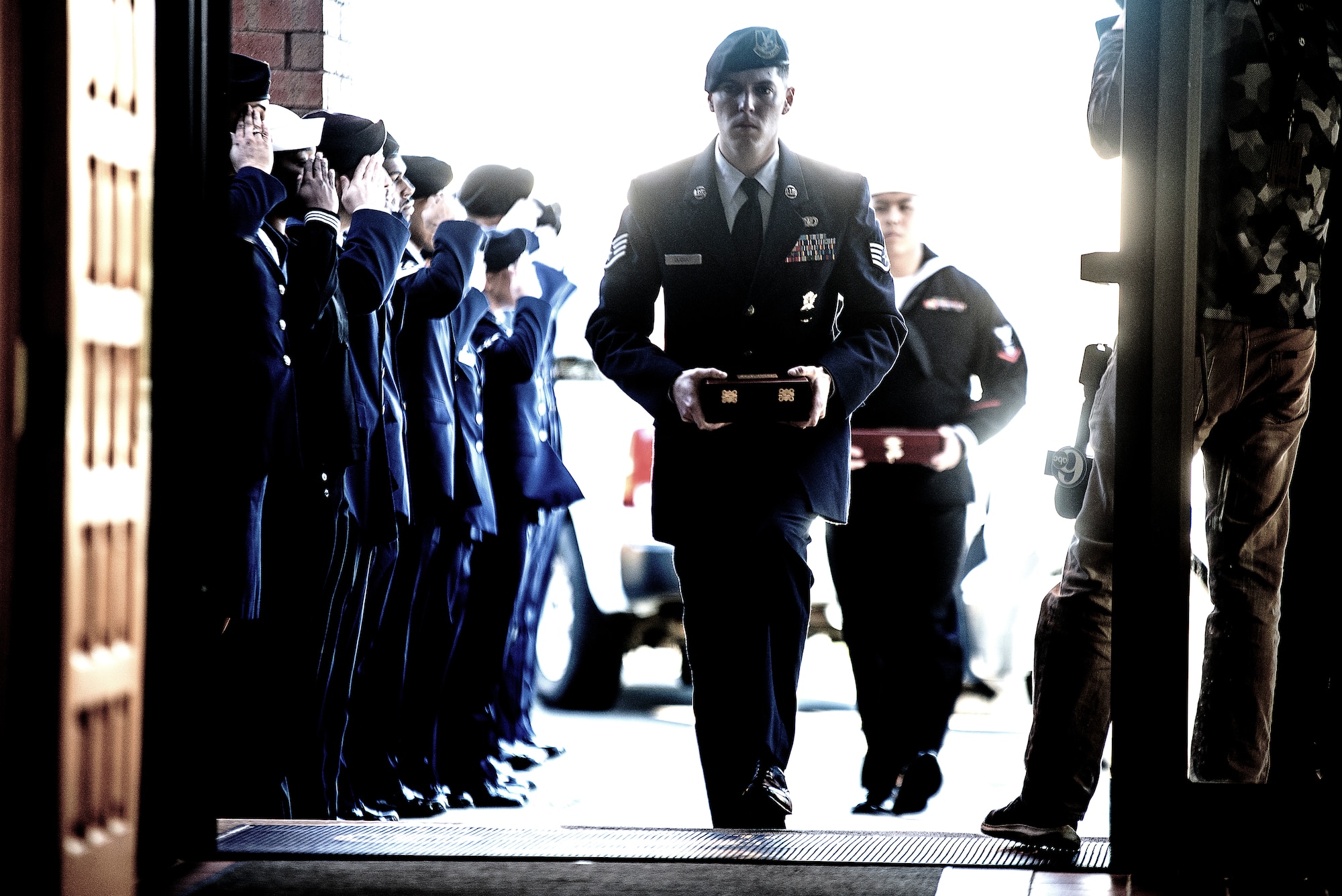 U.S. Air Force Staff Sgt. Alec Ducsay and U.S. Navy Petty Officer 3rd Class Jordan Sison, 87th Security Forces military working dog handlers, enter the McGuire Chapel on Joint Base McGuire-Dix-Lakehurst, New Jersey, carrying the remains of their military working dogs, Nov. 1, 2019. A memorial service was held for MWD Robby and MWD Bagira, who both served to protect Joint Base MDL as patrol explosive detector dogs.