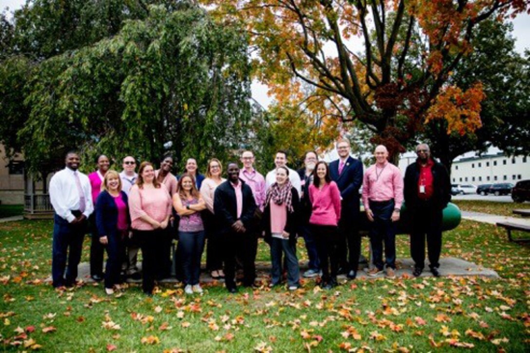 Photo of 20 people wearing pink shirts.