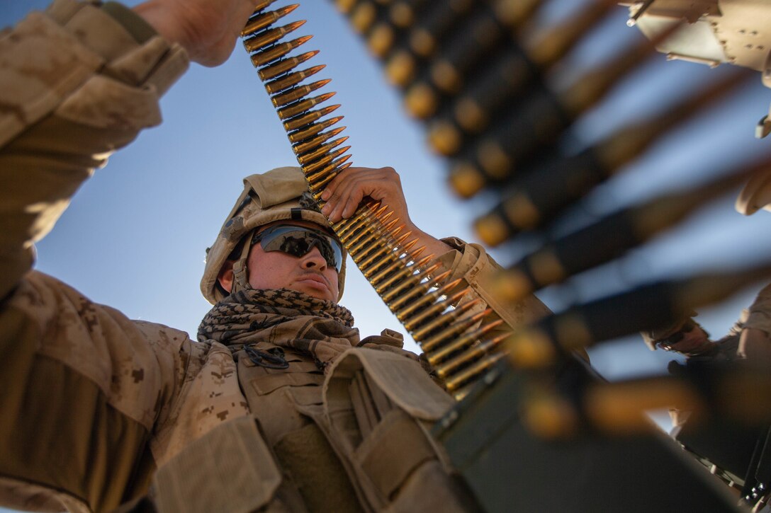 A Marine looks over a roll of bullets.