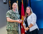 Defense Logistics Agency Land and Maritime Commander Navy Rear Adm. John Palmer accepts a Leadership Development Council coin from newly elected LDC president Christina McCoy for sharing his leadership perspective during his Into the Gray presentation Oct. 30 in the Building 20 Auditorium.