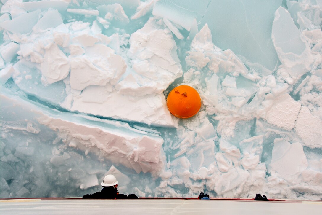 An orange buoy sits in frozen icy waters.