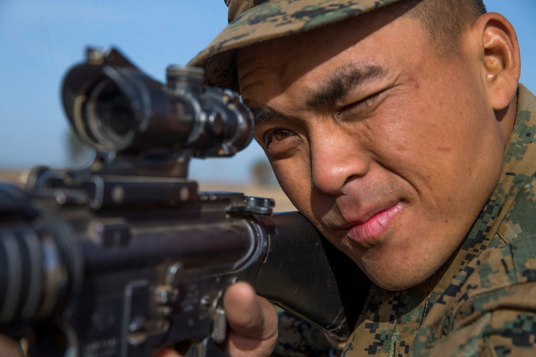 A Marine Corps recruit looks through a weapon scope.