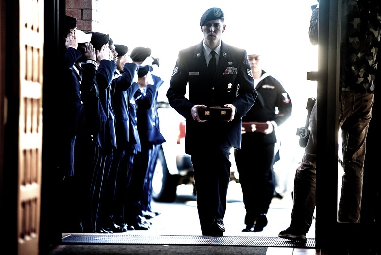 U.S. Air Force Staff Sgt. Alec Ducsay and U.S. Navy Petty Officer 3rd Class Jordan Sison, 87th Security Forces military working dog handlers, enter the McGuire Chapel on Joint Base McGuire-Dix-Lakehurst, New Jersey, carrying the remains of their military working dogs, Nov. 1, 2019. A memorial service was held for MWD Robby and MWD Bagira, who both served to protect Joint Base MDL as patrol explosive detector dogs.