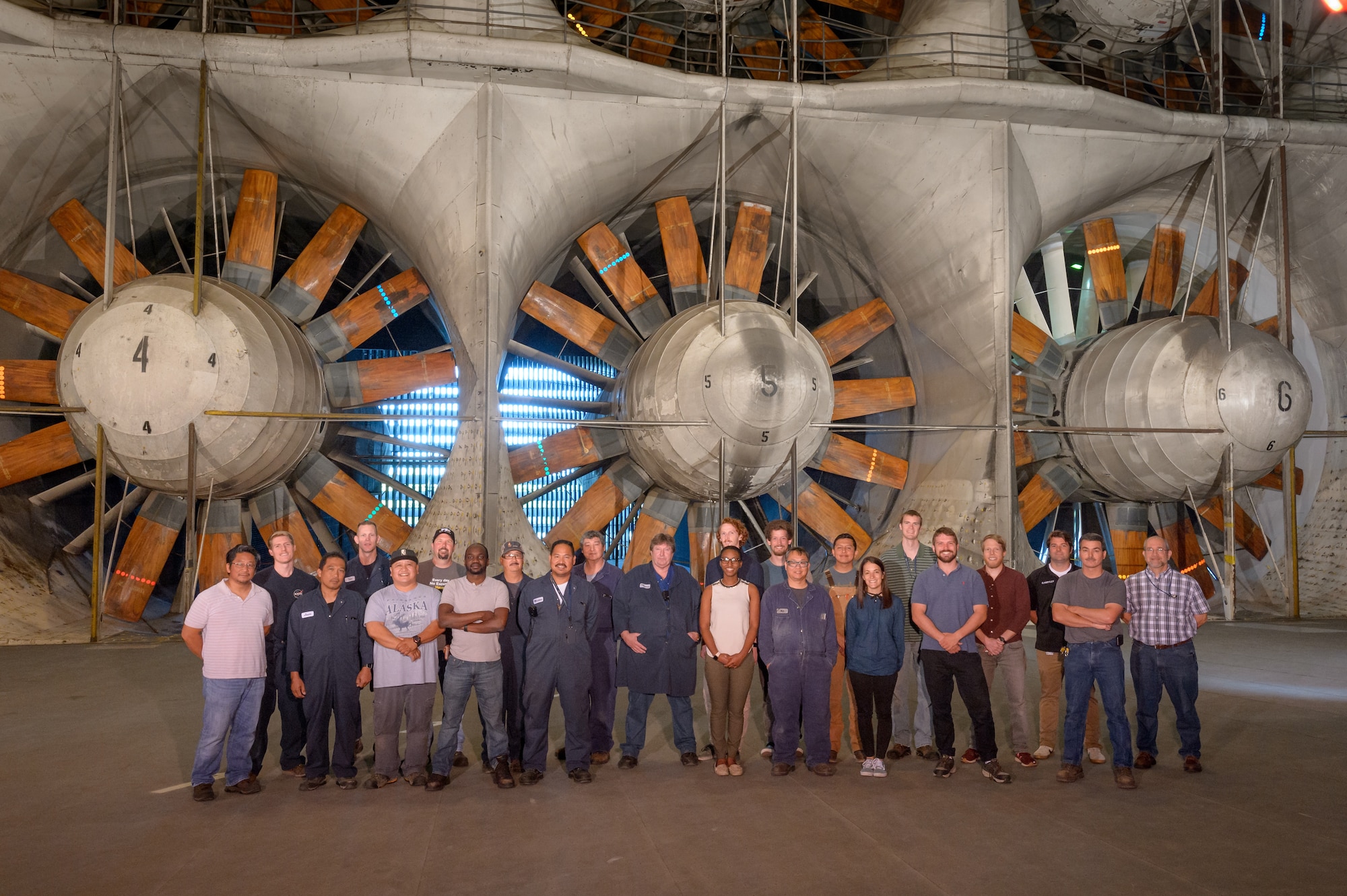 The Arnold Engineering Development Complex National Full-Scale Aerodynamics Complex (NFAC) return-to-service crew document their work on the 40- by 80-foot test section with a photo. In 2017, a collapsed wall panel at NFAC, located at Moffett Field in Mountain View, California, damaged one of the six large fan motors, pictured in the background, which powers the complex wind tunnels. NFAC craftsmen worked alongside engineers to successfully return the 40- by 80-foot test section to service in 2018. (U.S. Air Force photo)