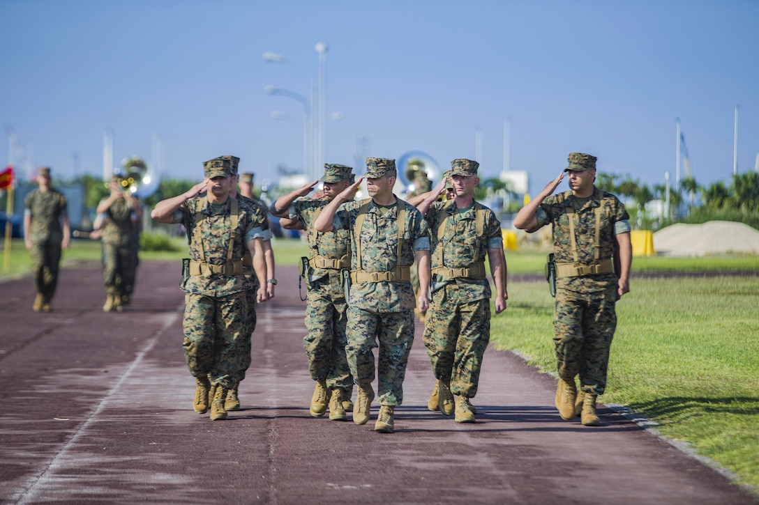 A group of Marines salute.