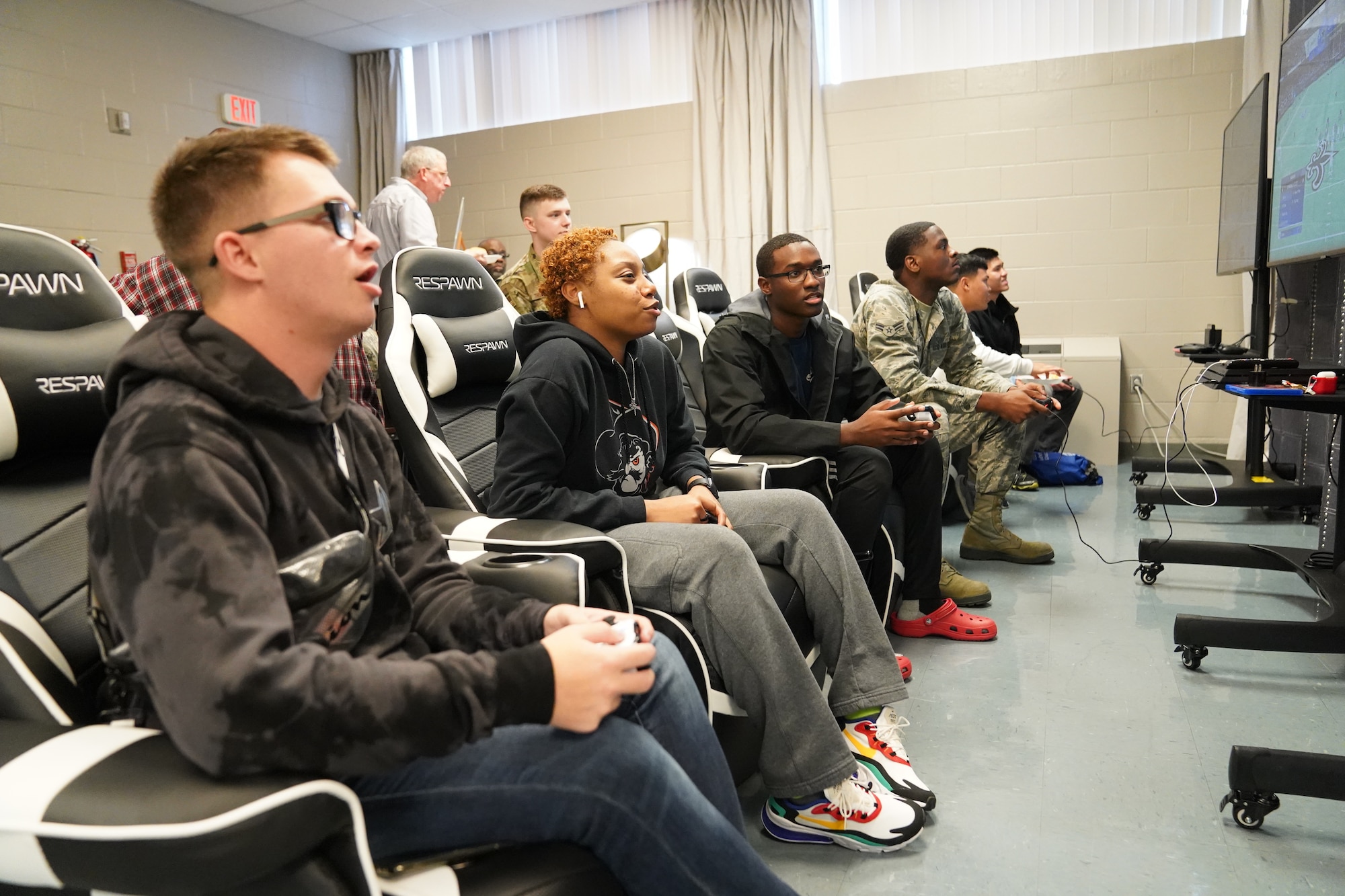 Keesler Airmen play video games during the opening of The Lighthouse inside the Larcher Chapel at Keesler Air Force Base, Mississippi, Nov. 1, 2019. The Lighthouse is a place dedicated to permanent party Airmen complete with gaming stations, massage chairs, a kitchen, and a music room. The idea of the lighthouse stemmed from a meeting Col. Heather Blackwell, 81st Training Wing commander, had with some of Keesler's dorm residents in August. (U.S Air Force photo by Airman 1st Class Spencer Tobler)