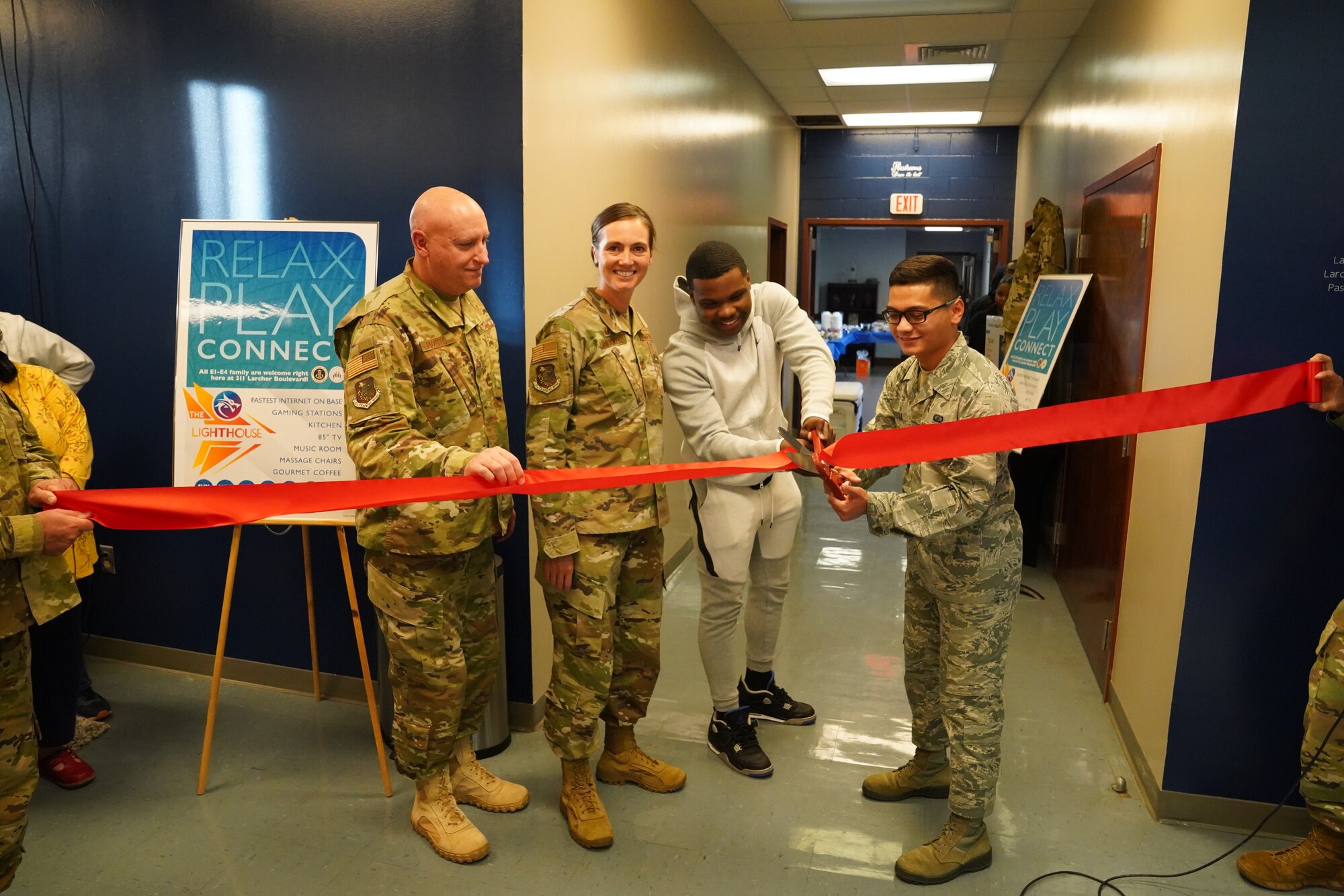 Keesler leadership and Airman's Council members cut the ribbon to the The Lighthouse inside the Larcher Chapel at Keesler Air Force Base, Mississippi, Nov. 1, 2019. The Lighthouse is a place dedicated to permanent party Airmen complete with gaming stations, massage chairs, a kitchen, and a music room. The idea of the lighthouse stemmed from a meeting Col. Heather Blackwell, 81st Training Wing commander, had with some of Keesler's dorm residents in August. (U.S Air Force photo by Airman Seth Haddix)