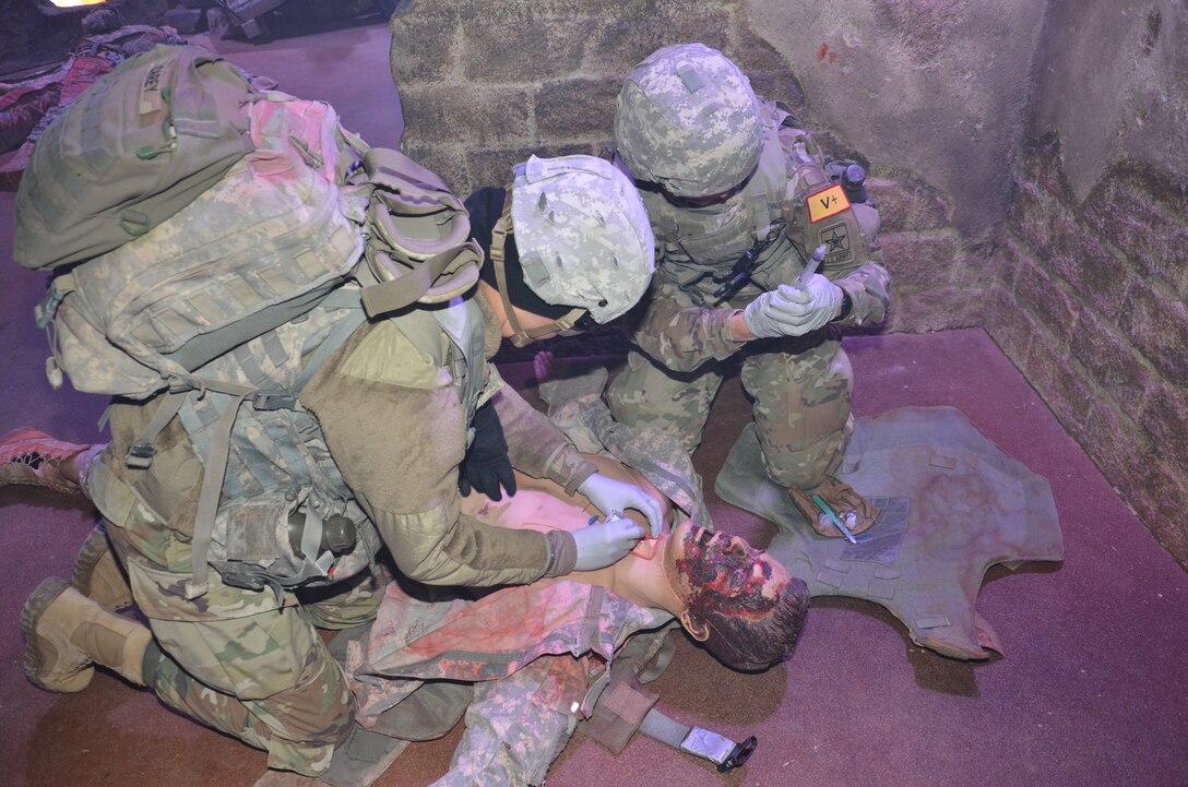 Combat Medic Training program students at the Medical Education and Training Campus at Joint Base San Antonio-Fort Sam Houston conduct an emergency cricothyrotomy on a “casualty” during simulation training. The “wounded” manikin also presents with facial burns that were created with moulage techniques.