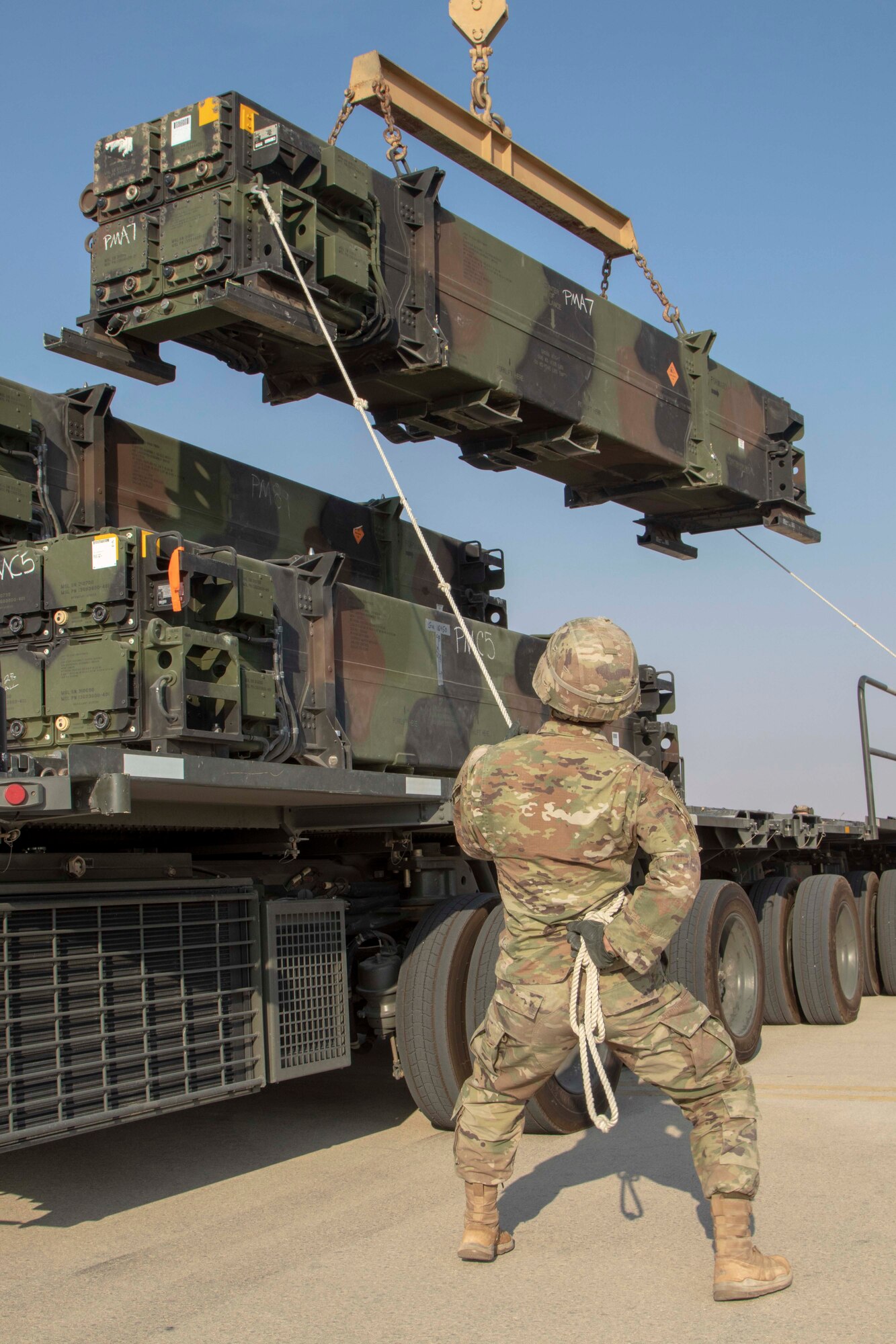A soldier from Alpha Battery, 4th Battalion, 5th Air Defense Artillery, 69th Air Defense Artillery Brigade works with his team removes missiles from a trailer in preparation to reload their Patriot Launching Station.
