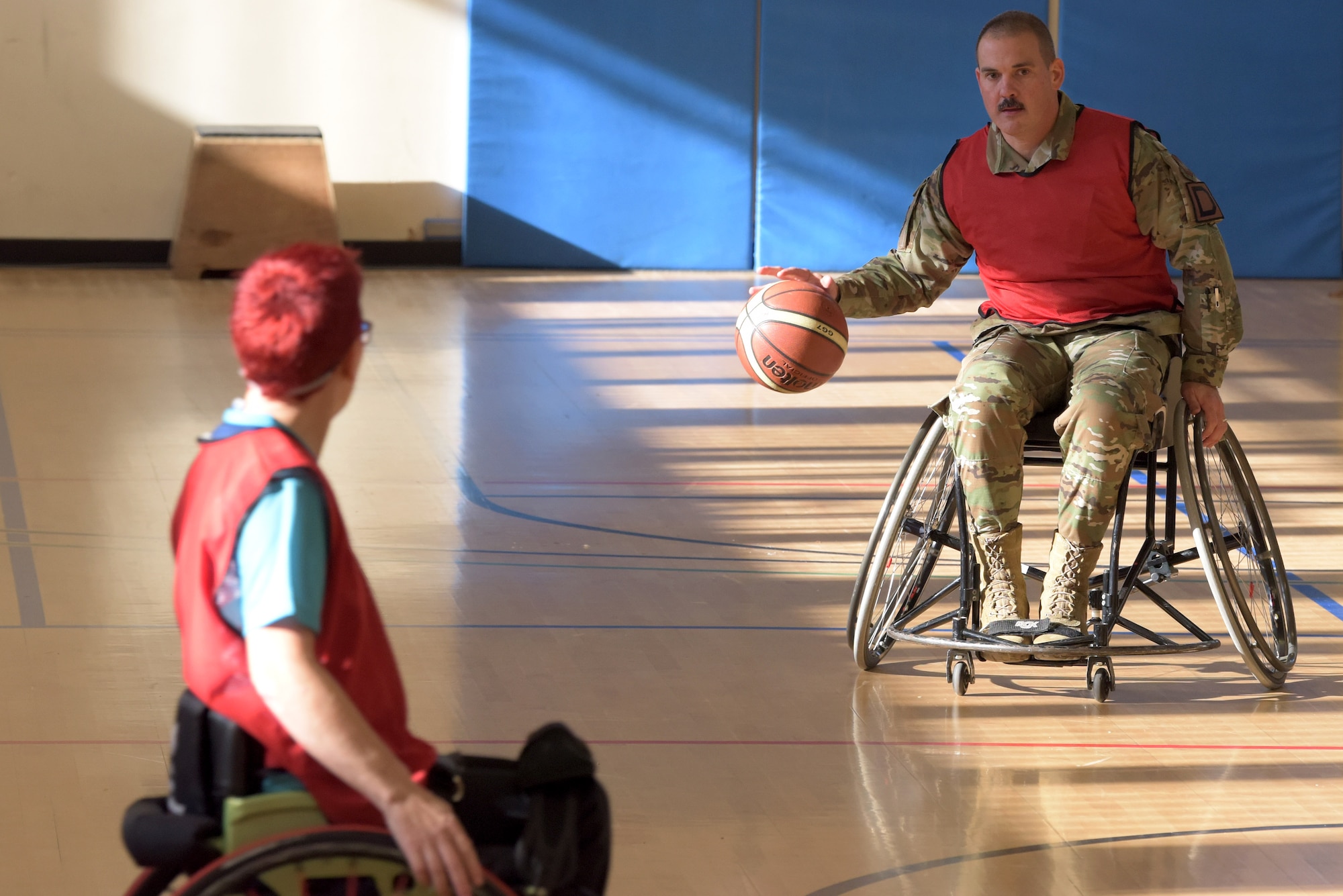 Col. Robert Shelton, 100th Operations Group commander, dribbles a basketball during a wheelchair basketball event at RAF Mildenhall, England, Oct. 30, 2019. The event was part of National Disability Employment Awareness Month which aims to help increase employment and advancement opportunities for those with disabilities through awareness. (U.S. Air Force photo by Senior Airman Benjamin Cooper)