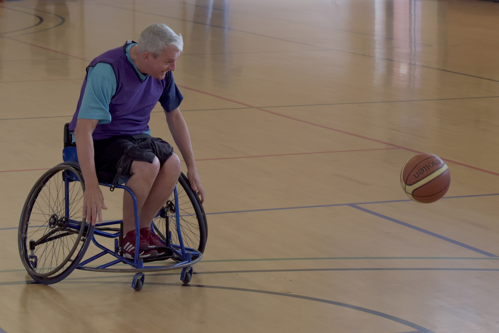 Chris Malloy, a member of the Hereward Heat wheelchair basketball club, chases a basketball during a wheelchair basketball event at RAF Mildenhall, England, Oct. 30, 2019. The event was part of National Disability Employment Awareness Month which aims to help increase employment and advancement opportunities for those with disabilities through awareness. (U.S. Air Force photo by Senior Airman Benjamin Cooper)